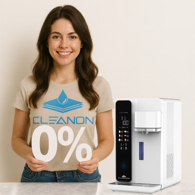Eine Frau hält in den Händen 0%, neben ihr steht ein Wasseraufbereitungsgerät von CLEANON PLUS W25