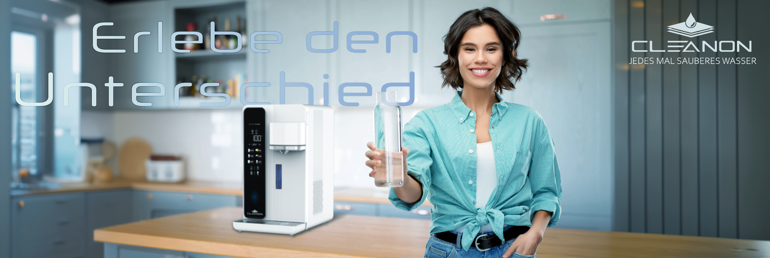Eine junge Frau steht in einer modernen Küche, lächelt in die Kamera und hält ein Glas sauberes Wasser in der Hand. Links neben ihr steht das CLEANON PLUS Auftisch-Wasserfiltersystem auf einer Arbeitsplatte. Darüber der Schriftzug ‚Erlebe den Unterschied‘ in großen Buchstaben. Oben rechts ist das CLEANON-Logo mit dem Slogan ‚Jedes Mal sauberes Wasser‘ zu sehen.